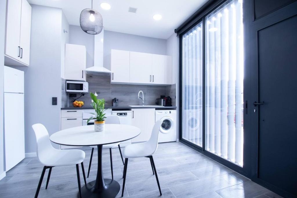 瓦伦西亚Patacona by Concept Flats的白色的厨房配有桌子和白色椅子