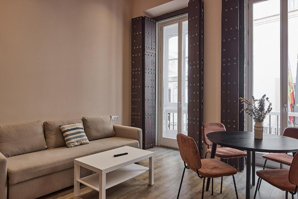 加的斯VG - Villa de Andas suites的客厅配有沙发和桌子