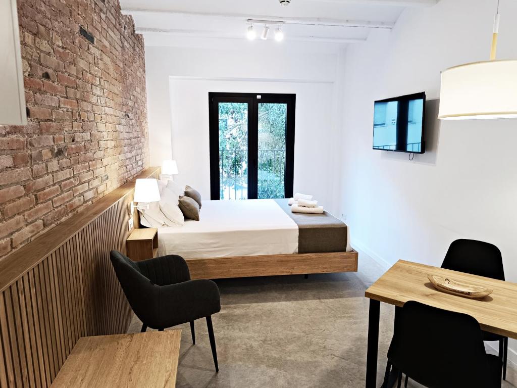 略夫雷加特河畔奥斯皮塔莱特ARIQUS Fira Apartments的一间卧室设有一张床和砖墙
