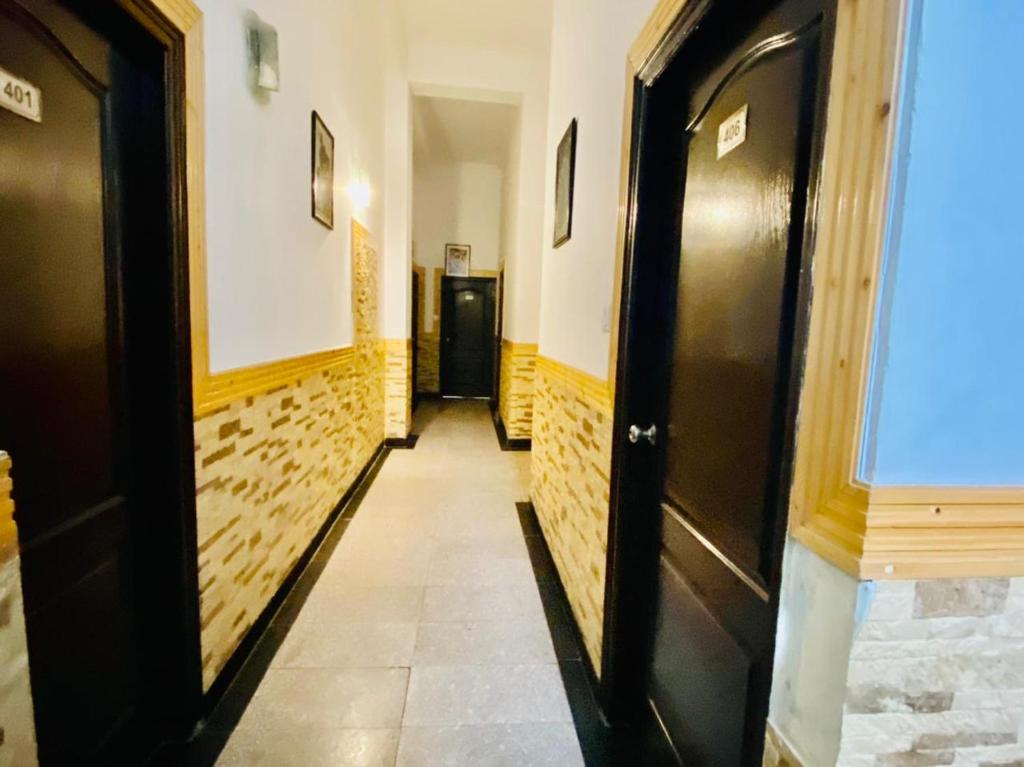 西姆拉Aachman velly view with terrace的走廊设有黑色门,铺有瓷砖地板