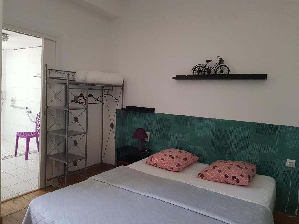 萨索内坎普尚布尔玫瑰小屋民宿的一间卧室配有带粉红色枕头的床。