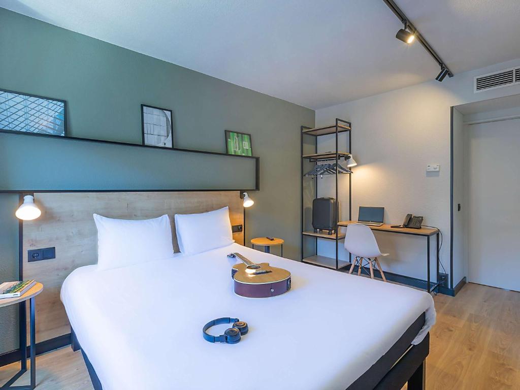 布拉干萨Hotel ibis Bragança的卧室配有一张白色大床和一张书桌