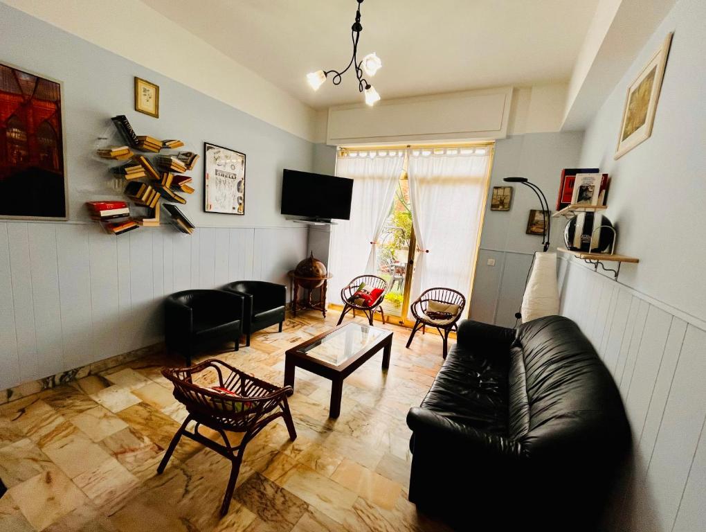 皮特拉利古Hotel Principe的客厅配有黑色真皮沙发和椅子