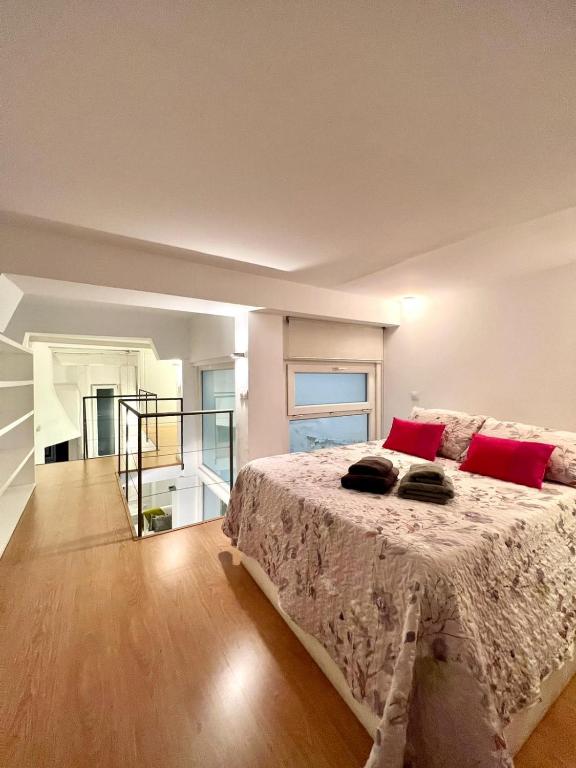 马德里Excelente loft en Trafalgar的一间卧室配有一张带红色枕头的大床