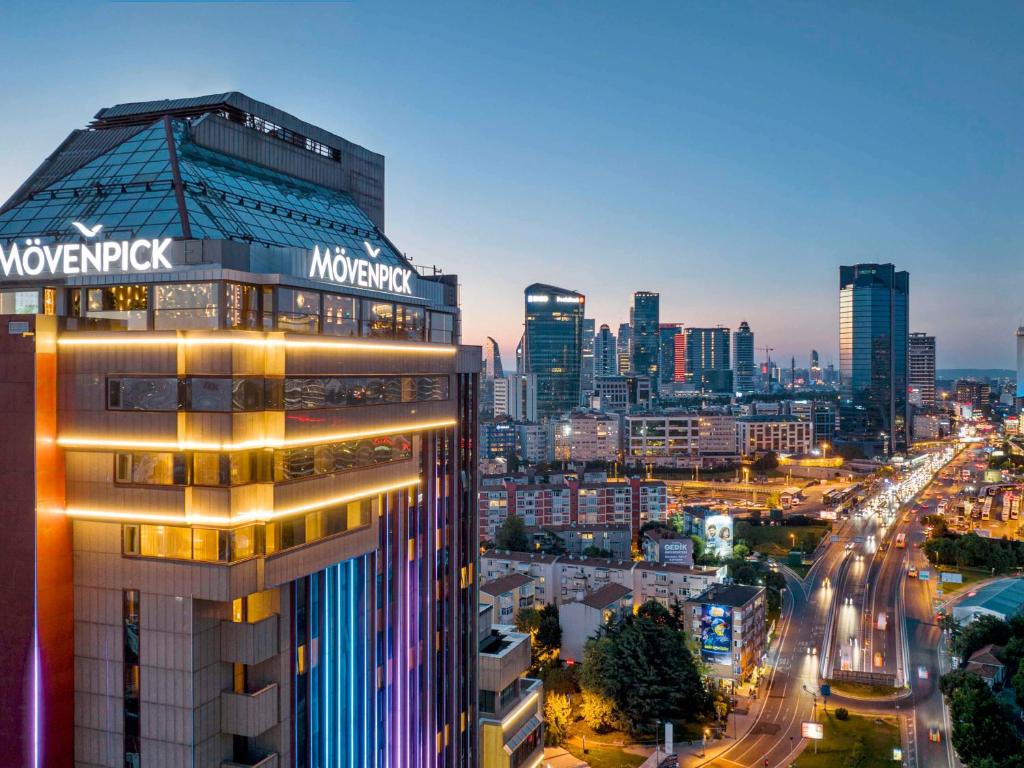 伊斯坦布尔Mövenpick Hotel Istanbul Bosphorus的享有夜间城市美景,设有一座建筑