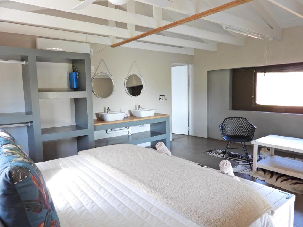 MohemeNewburg Lodge & Luxury Bush Tents, Elements Private Golf Reserve的一间卧室配有一张大床和一张书桌