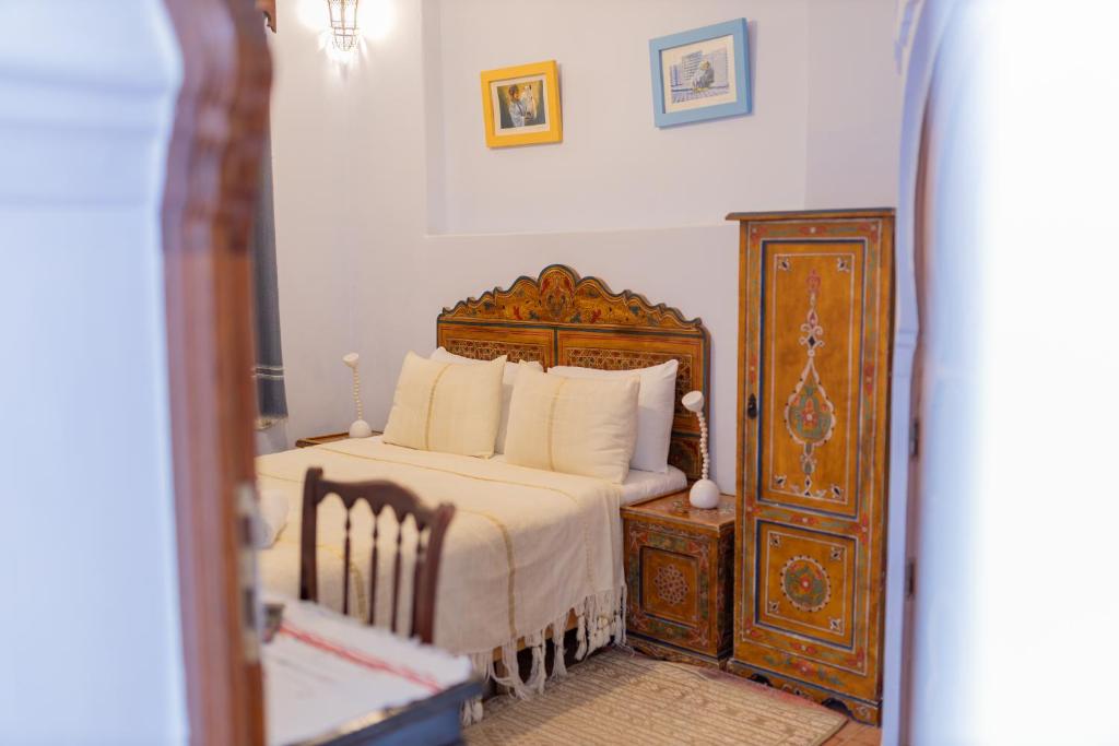 舍夫沙万卡萨萨比拉旅馆的一间卧室配有一张大床和一个木制梳妆台