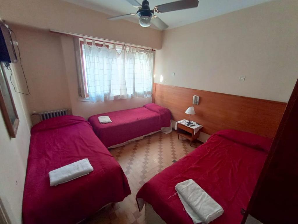 马德普拉塔Nuevo Hotel Tivoli的红色床单的客房内的两张床
