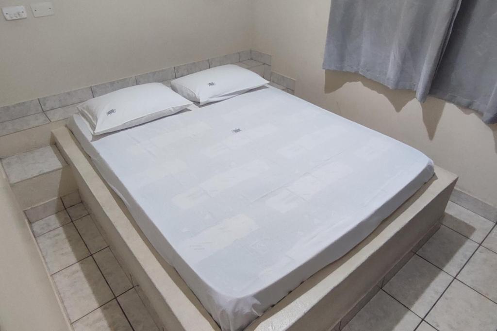 隆德里纳格瑞斯酒店的一张白色的床,坐在房间里