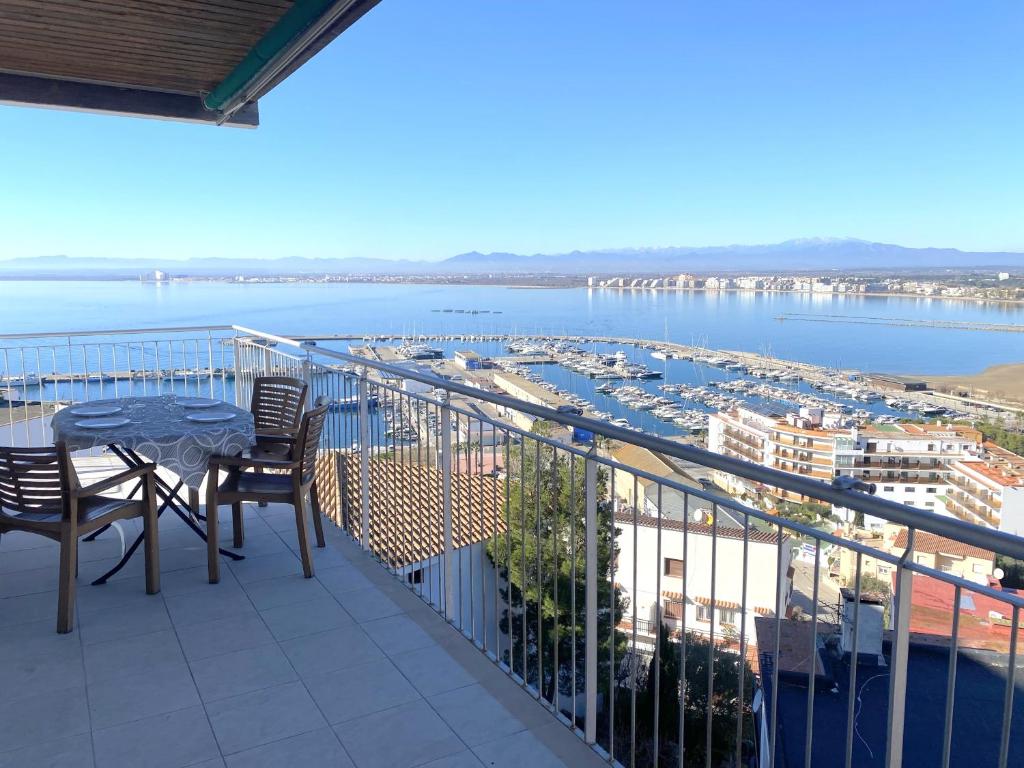 罗萨斯Angeles 9的阳台配有桌椅,享有海港的景致。