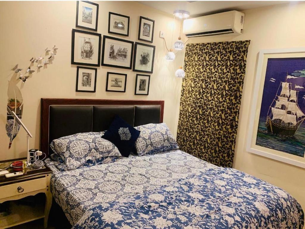 伊斯兰堡Entire One Bedroom Furnished Apartment的卧室配有一张床,墙上挂有图片