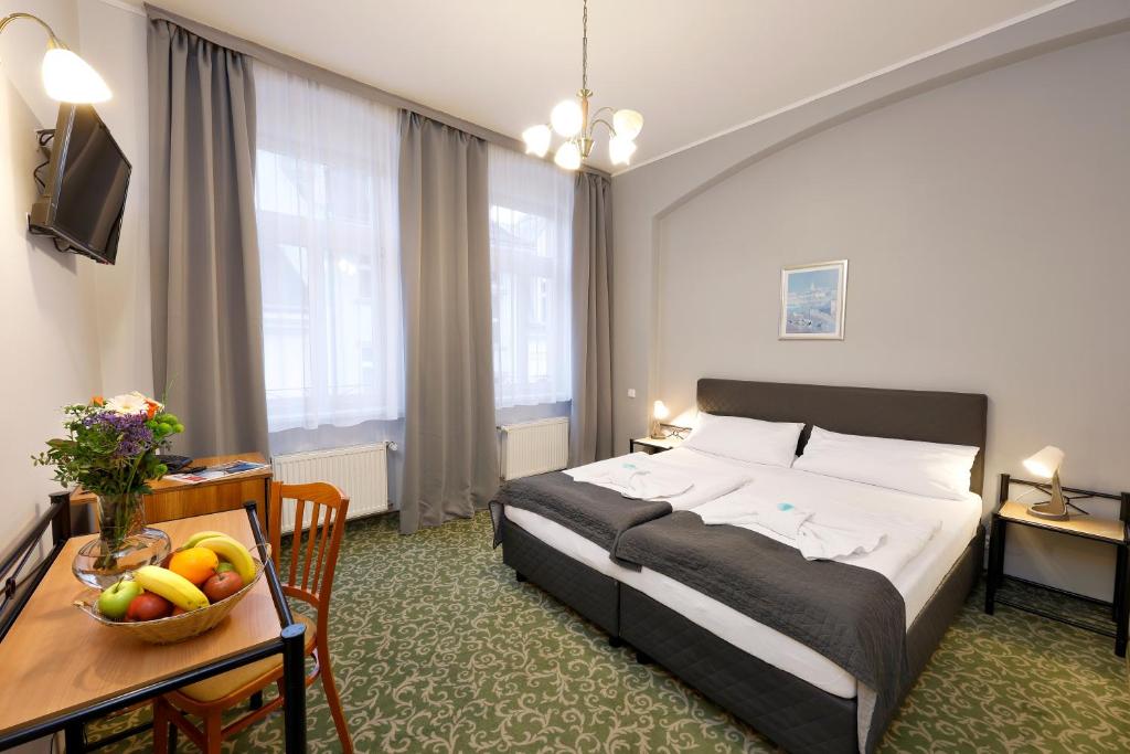 卡罗维发利波士顿酒店的酒店客房,配有一张床和一张桌子,还有一碗水果