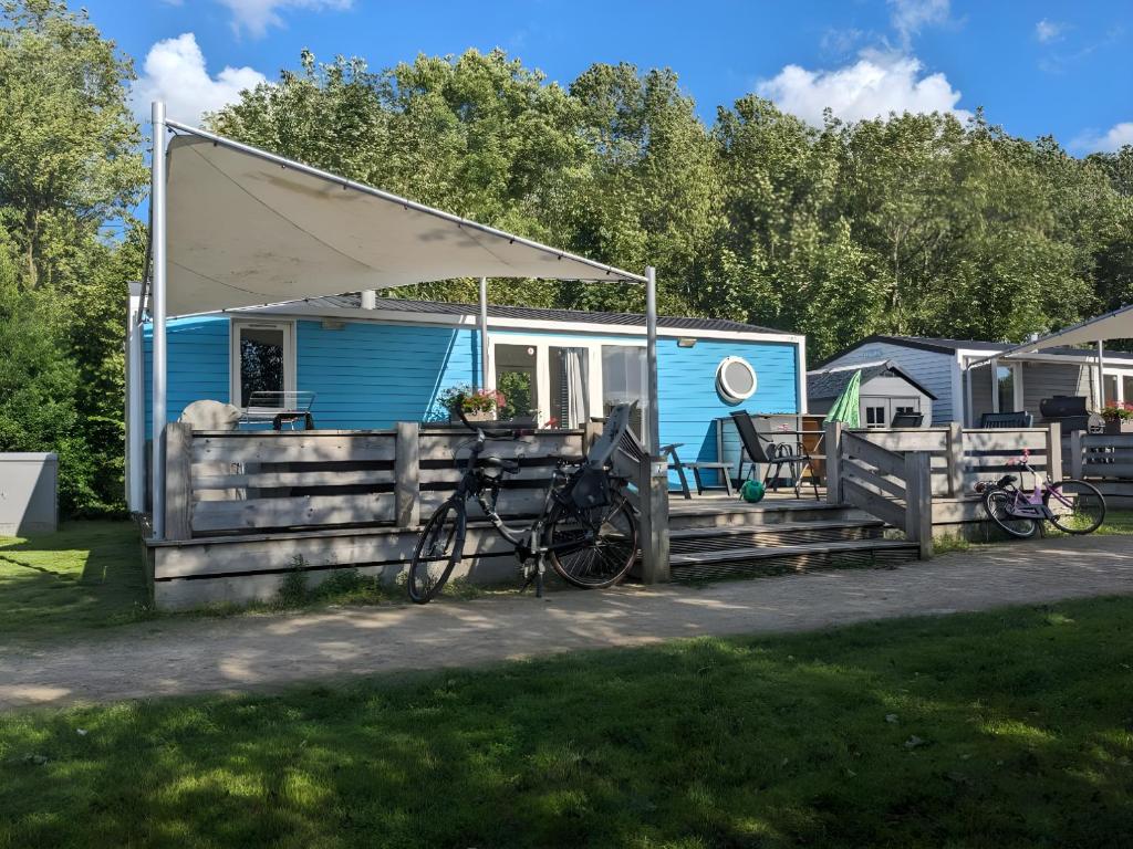KropswoldeCozy Tiny SolHouse 7 - Near Groningen - 5 Star Location的一辆蓝色大篷车,车停在车前