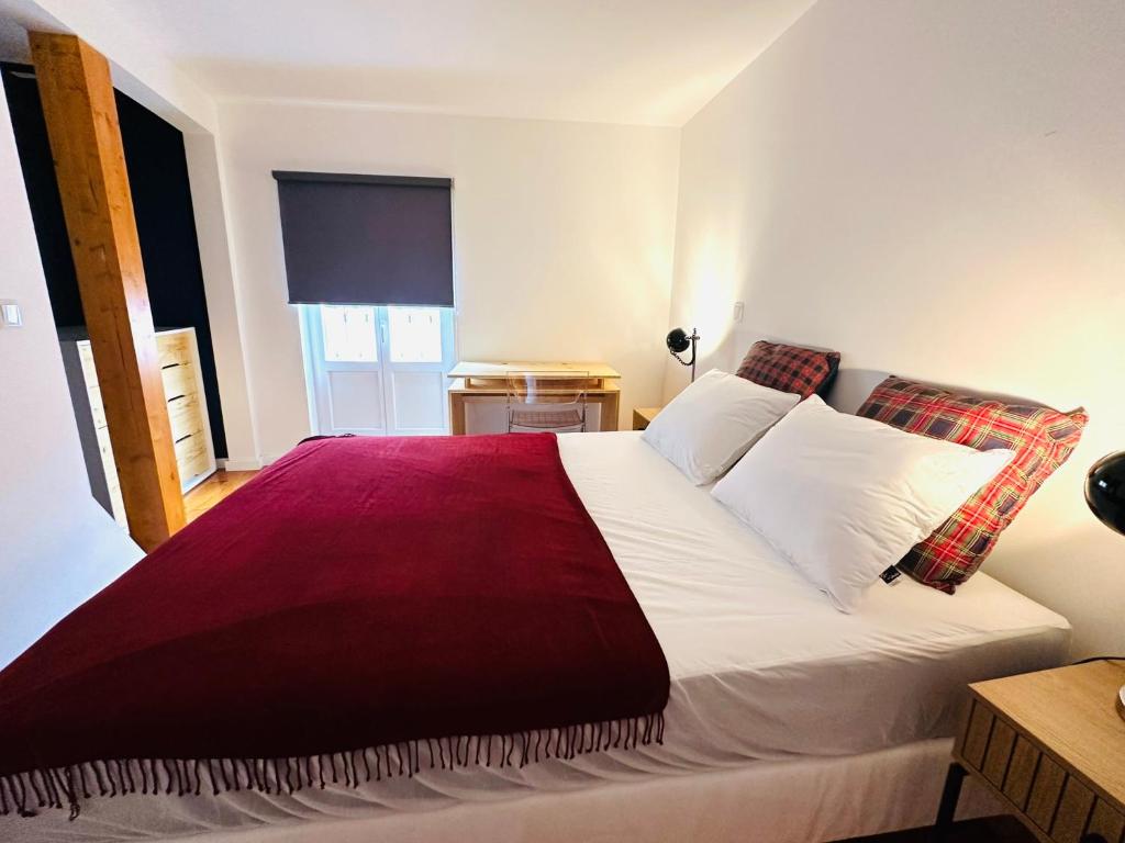 里斯本Castle cozy apartment的一间卧室配有一张带红色毯子的大床