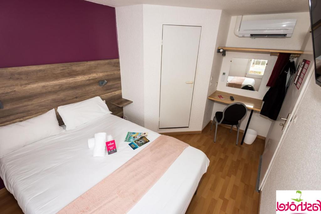 里摩日Fasthôtel - Un hôtel FH Confort的卧室配有白色的床和桌椅