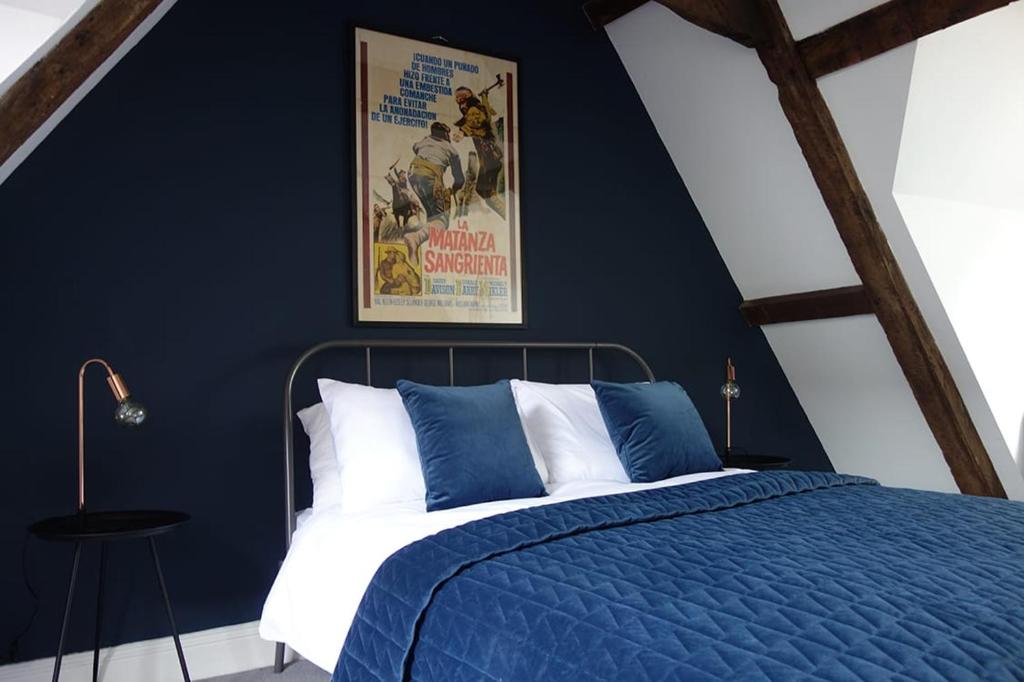 诺里奇Grade II Listed Flint Cottage Sleeps 4的蓝色的卧室设有一张床铺和一张墙上的海报