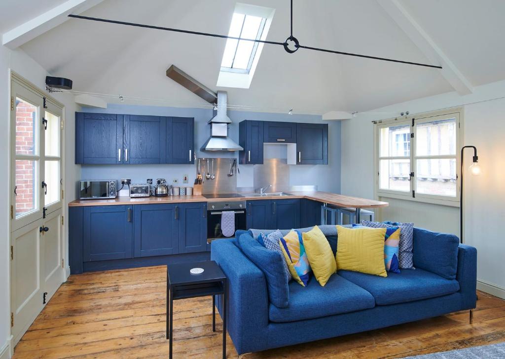诺里奇Studio 2 - Central Location Sleeps 4的一间带蓝色沙发的客厅和一间厨房