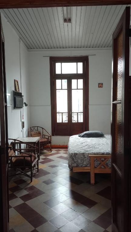 巴拉那Espacio Cultural Nuevo Micelio的一间卧室配有一张床、一张桌子和一个窗户。