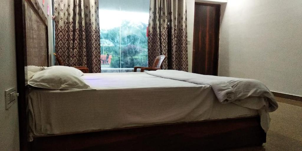 克久拉霍Hotel Radha Rani Mahal的一间卧室配有一张带窗户和镜子的床