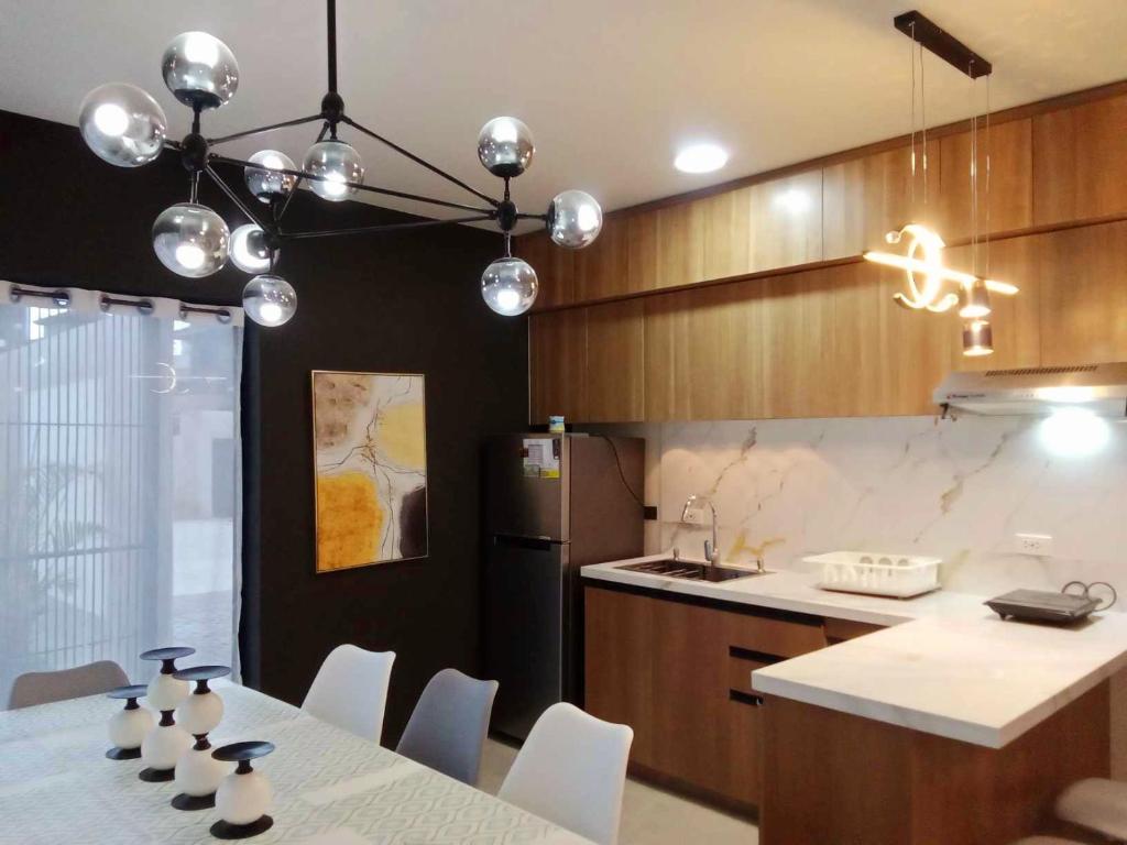 八打雁Beach Hive Seafront Residences Villa in San Juan Batangas的厨房配有桌椅和冰箱。