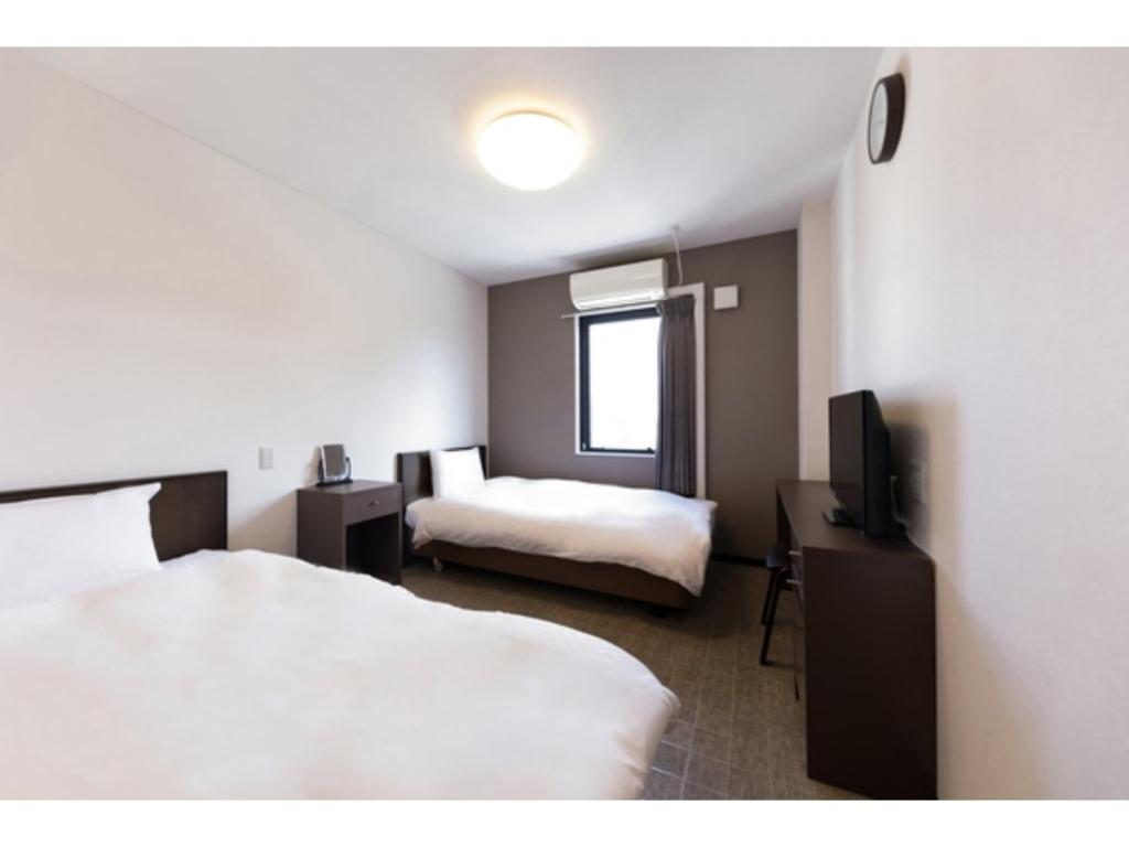 大阪OKINI HOTEL namba - Vacation STAY 40741v的酒店客房设有两张床和电视。