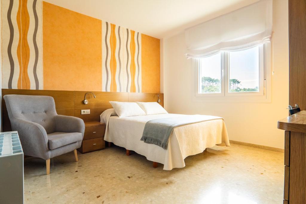 波多诺伏卡萨阿尔瓦利多旅馆的卧室配有床、椅子和窗户。