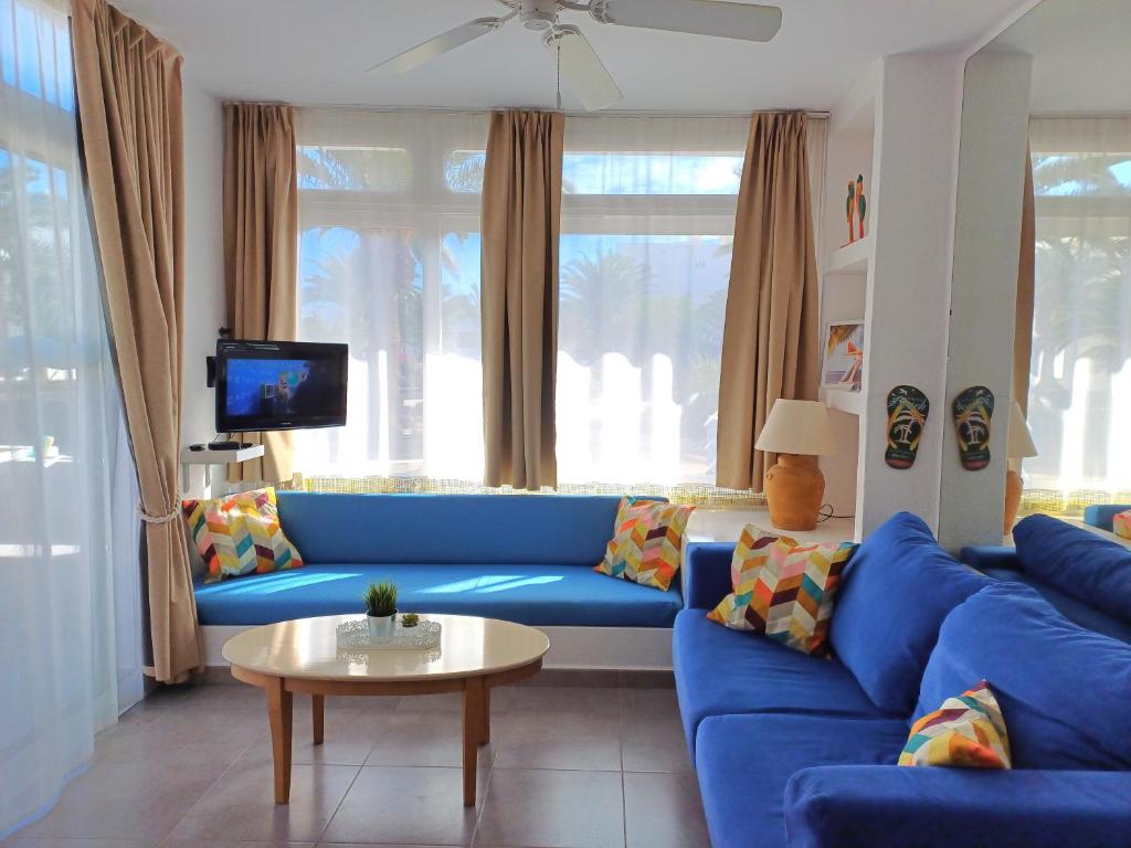科斯塔特吉塞Happy Heart Los Molinos的客厅配有蓝色的沙发和桌子