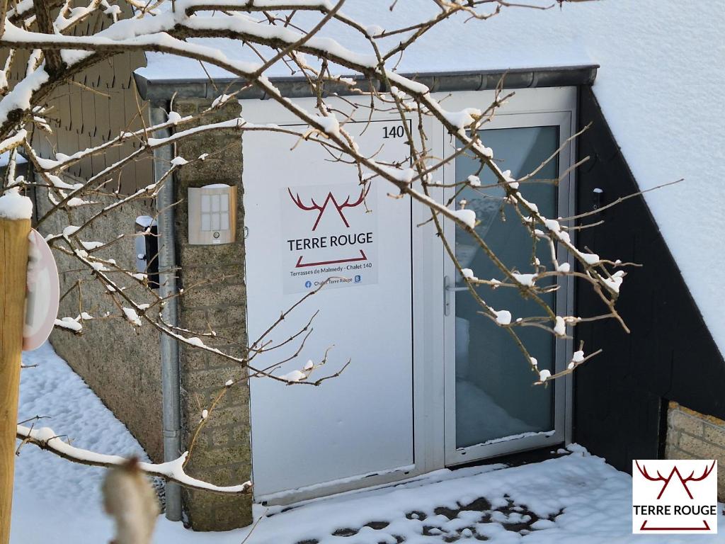 马尔梅迪Terre Rouge - Terra Rubica - Les Terrasses de Malmedy的雪中夹板房子的门
