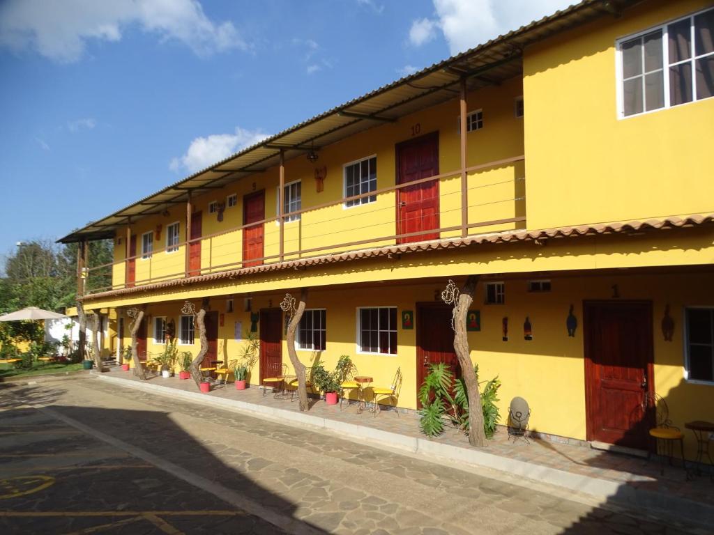 康塞普西翁德阿塔科Hostal Juarez Ataco的街上有红色门的黄色建筑