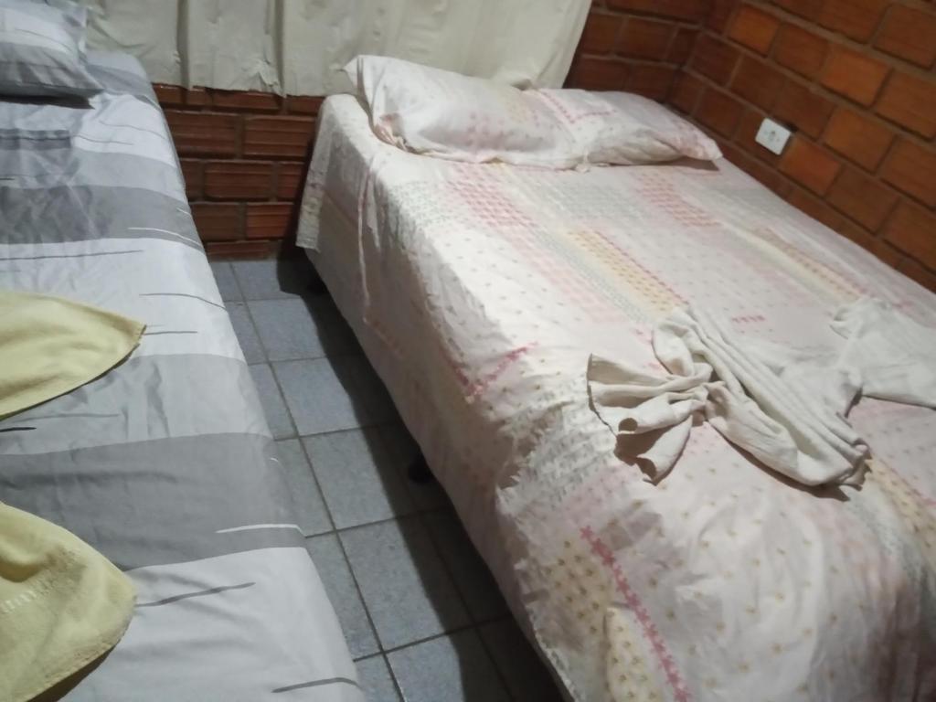 嘎林海斯港Casa de Porto de Galinhas 137的一张铺有白色床单的床,上面有弓