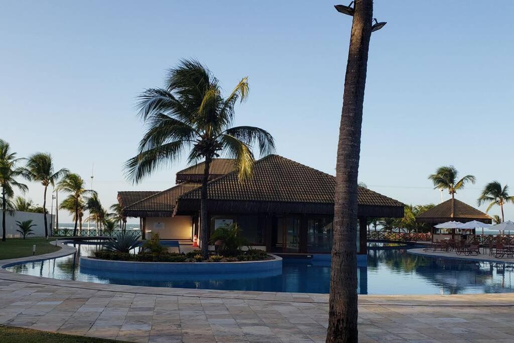 弗雷谢拉斯Flecheiras Eco Residence Un302的一个带游泳池和棕榈树的度假村