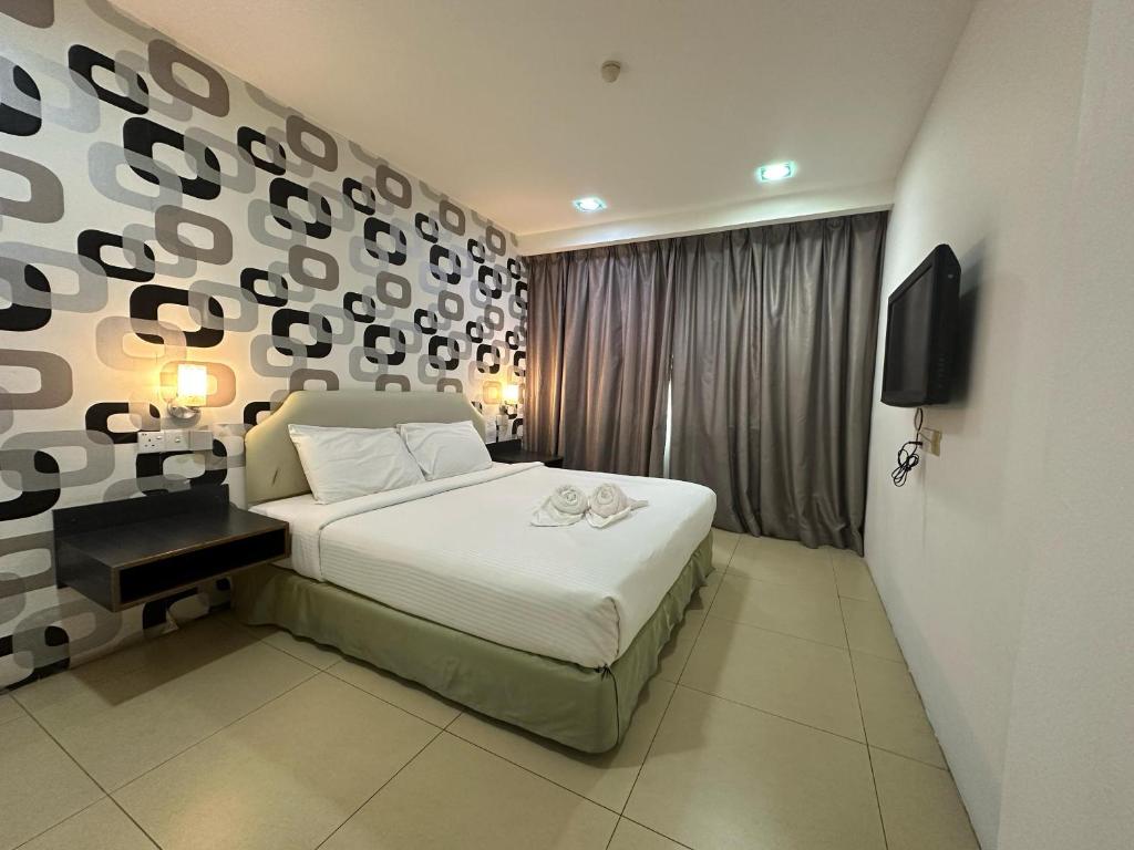 关丹Alia Express Hotel Twelve a12 Kuantan的一间卧室设有一张大床和一面墙