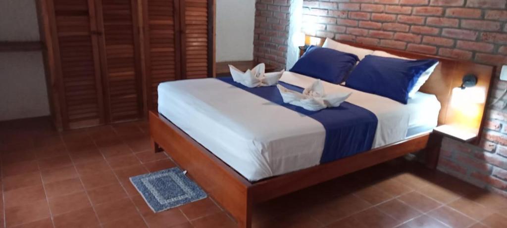 赛姆Hosteria Cumilinche的一间卧室配有一张带蓝色枕头的大床