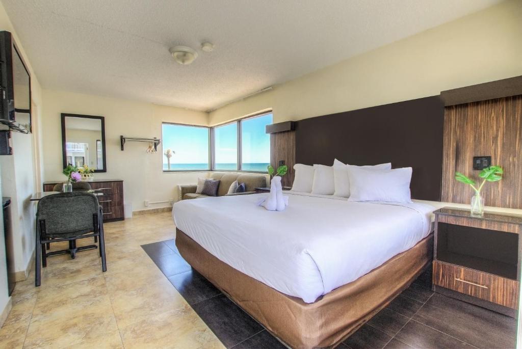 代托纳海滩La Bella Oceanfront Inn - Daytona的酒店客房设有一张大床和一张书桌。