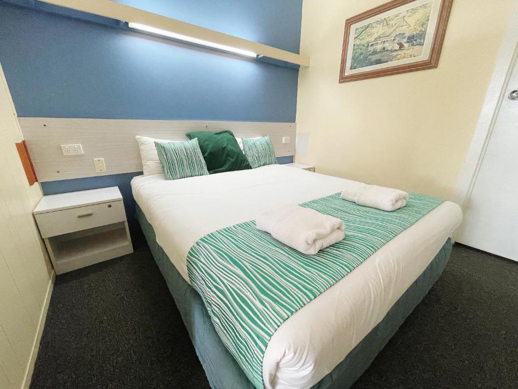 玛丽伯勒阿卡纳汽车旅馆的一间卧室配有一张床,上面有两条毛巾
