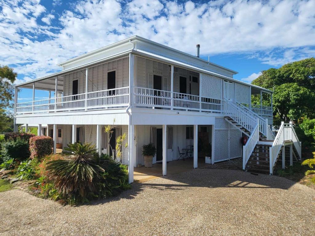 Emu ParkRibbonwood Bed & Breakfast, Emu Park Qld的白色的大房子,设有门廊和楼梯