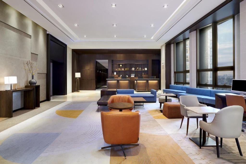 首尔Four Points by Sheraton Josun, Seoul Station的一个带沙发和椅子的酒店大堂