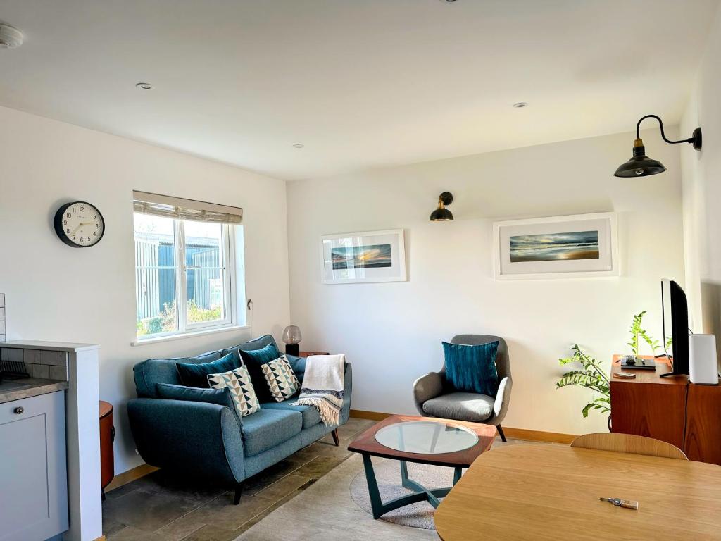 金斯布里奇Furlong Cottage @ Higher Stancombe Farm的客厅配有蓝色的沙发和桌子