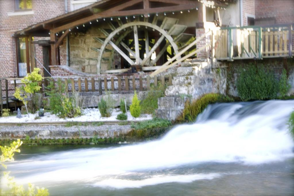 圣奥梅尔昂绍塞Logis - Hôtel & Restaurant Moulin Des Forges的瀑布屋边的水轮