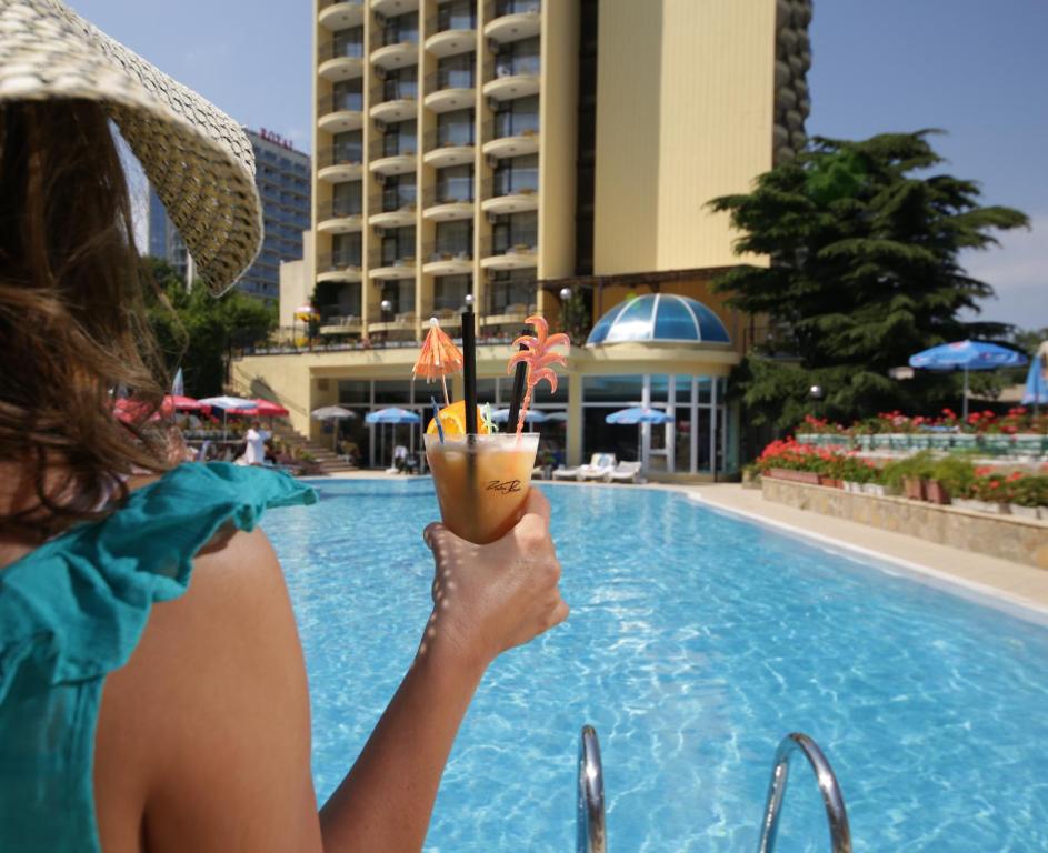 金沙希普卡酒店的女人在游泳池前喝一杯