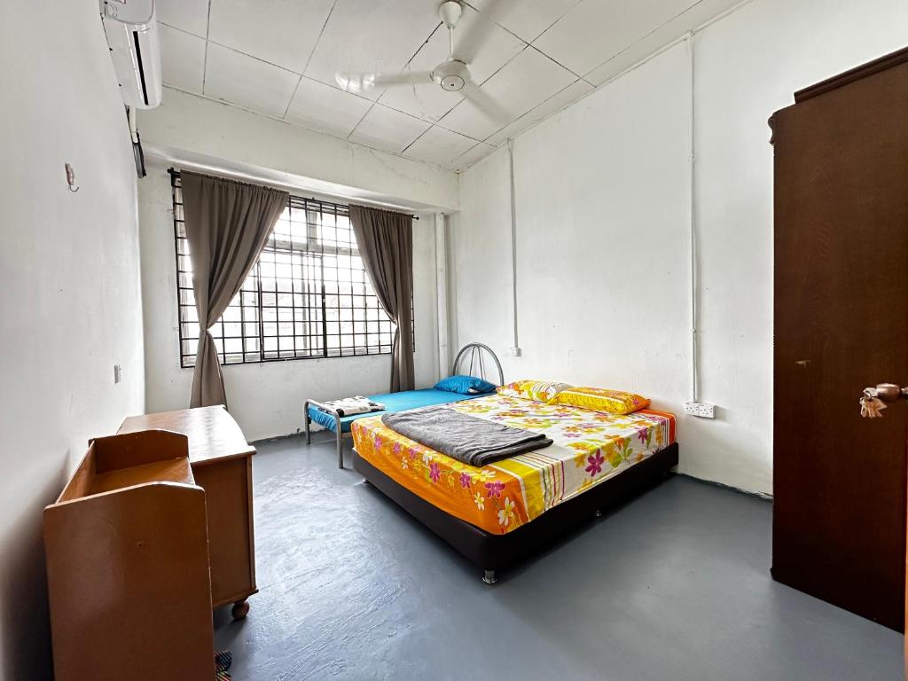 乌鲁地南Jiaxin Dormitory - Puteri Wangsa 家馨旅舍的一间卧室配有一张床和一张桌子
