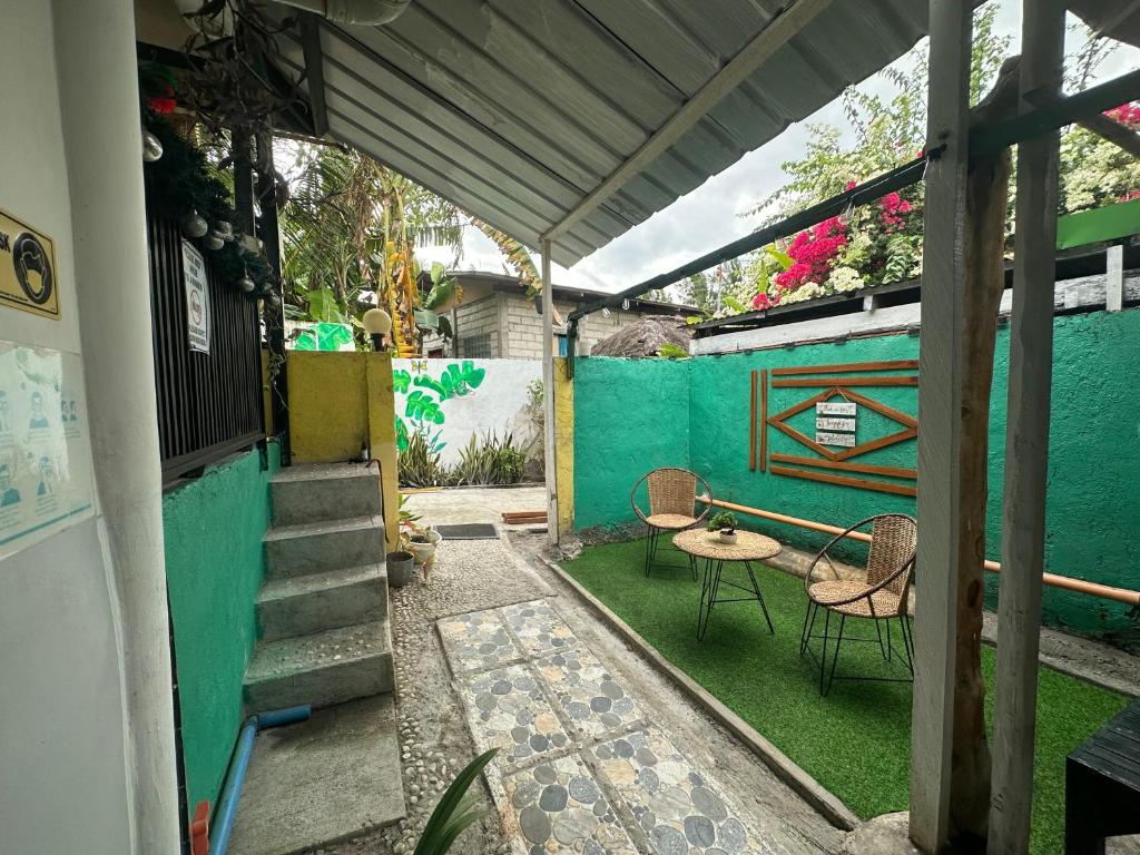 巴迪安Maui's Place的一个带桌椅和绿色墙壁的庭院