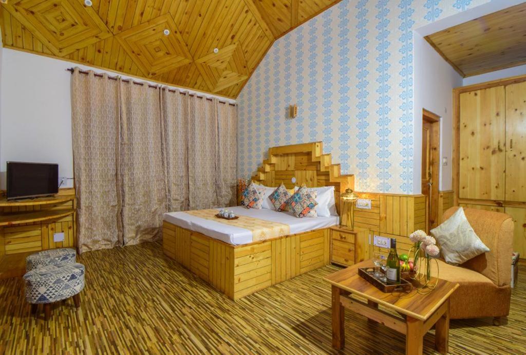 马拉里Hotel Hadimba Manali By YB Hotels的一间卧室配有一张床、一张沙发和一张桌子