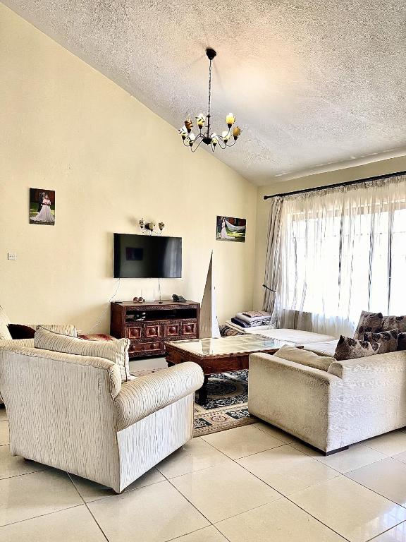 内罗毕Westlands Escape-Homestay的客厅配有两张沙发和一台电视机