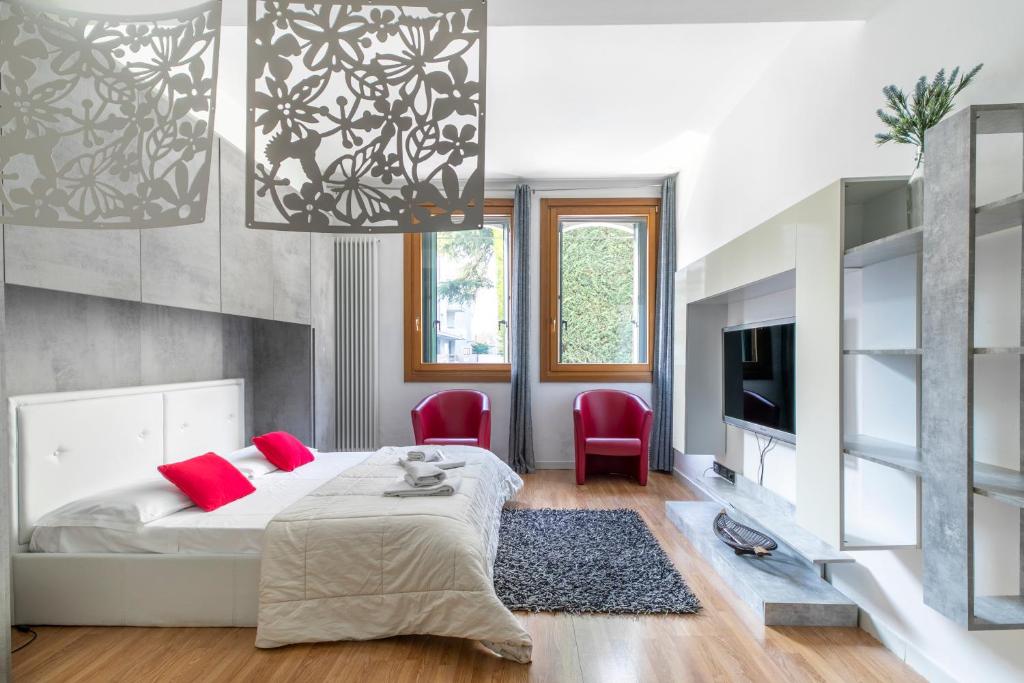 马格拉LA MAR Apartment Chirignago的一间卧室配有一张床和两张红色椅子