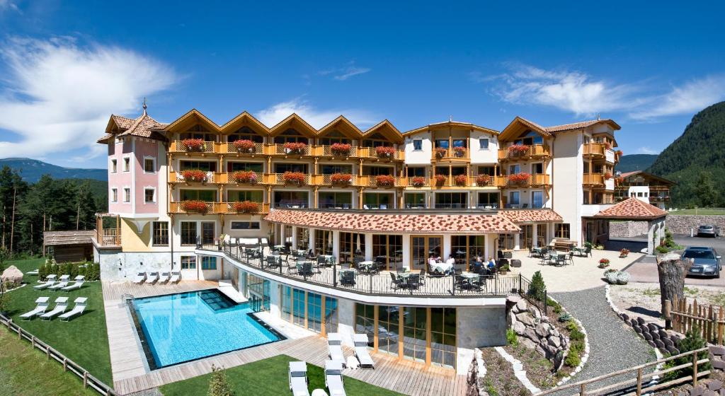卡斯特尔罗托Hotel Chalet Tianes - Alpine Relax的享有带游泳池的度假村的空中景致