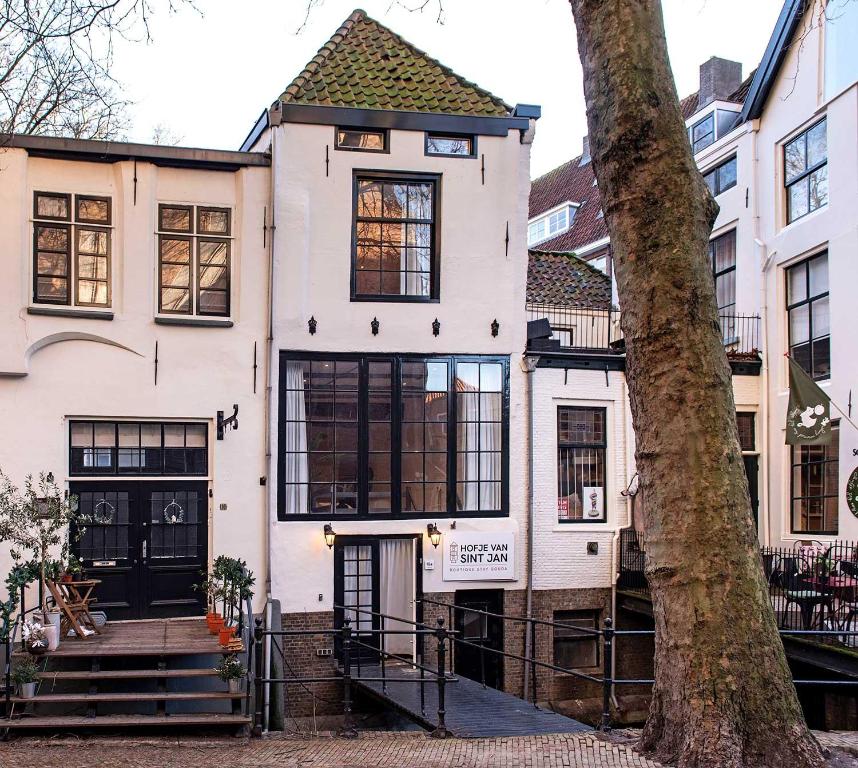 豪达Hofje van Sint Jan的前面有一棵树的白色房子