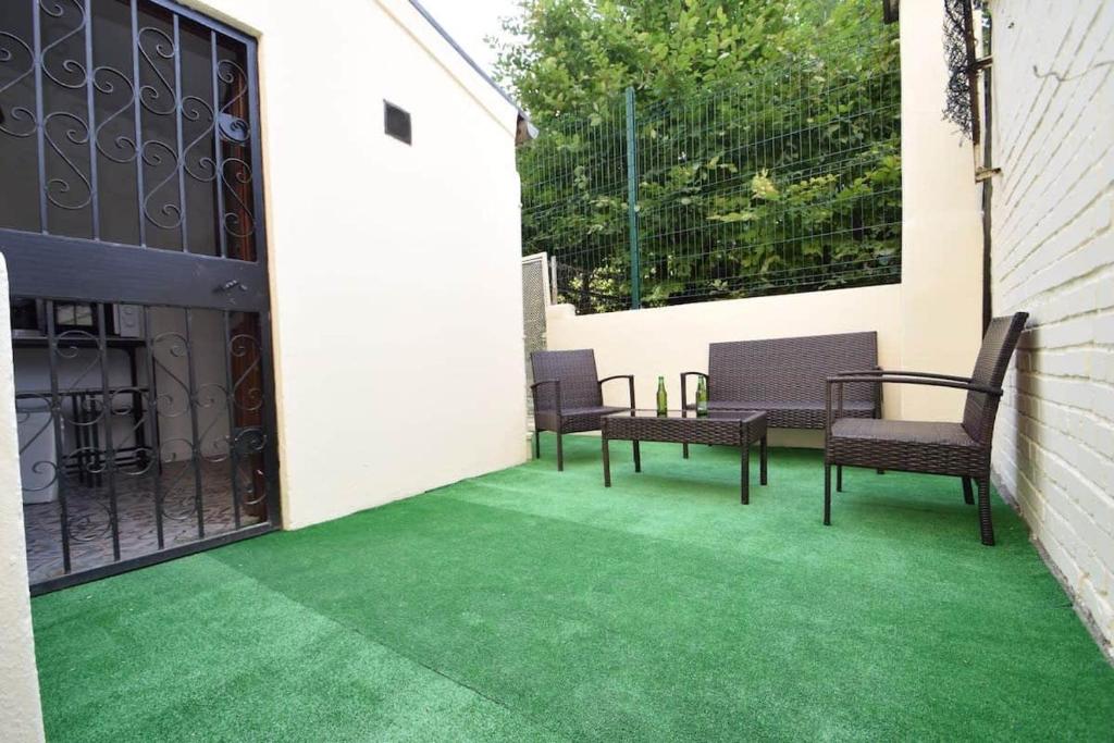 圣但尼Maison de ville haut de gamme En face du stade de France的一个带绿色地板、椅子和围栏的庭院