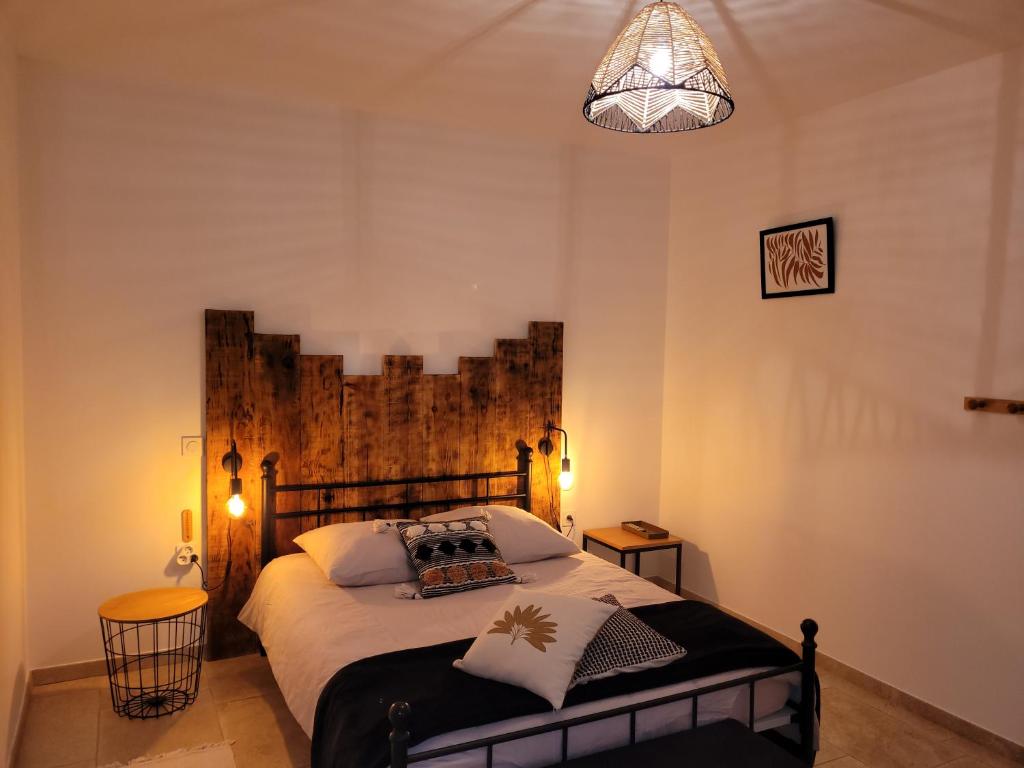 LasséranLa Gurlanne的一间卧室配有一张大床和木制床头板