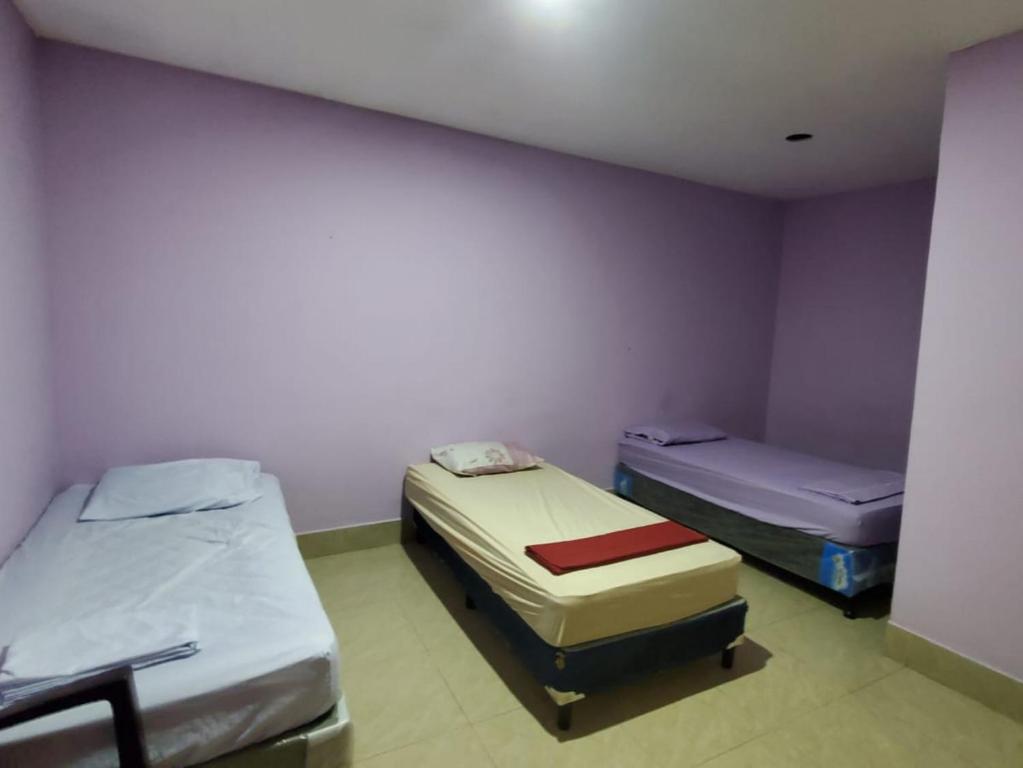 JinotegaHotel Putin的紫色墙壁客房的两张床